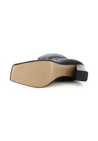 Schwarzer Leder-Highheel mit breitem, quadratischem Absatz und glattem Obermaterial. Die Sohle ist tan und hat ein strukturiertes Grip-Muster. Minimalistisches Design.