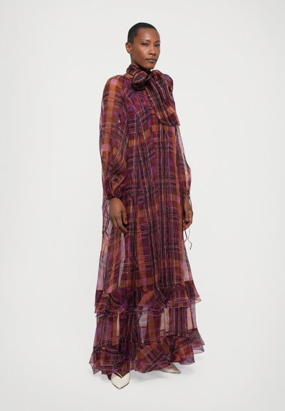 Lange, vloeiende jurk van doorschijnende plaid stof met paarse, oranje en bruine tinten. Rimpelzoom en hoge hals met een strikdetail.