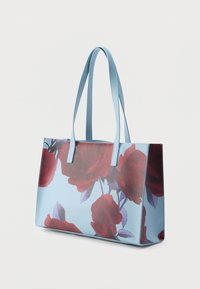 Lielas sarkanas rožu rakstu auduma soma ar gaismzilu fonu. Divas plānas zilas rokturi un struktūrēts taisnstūrveida dizains.