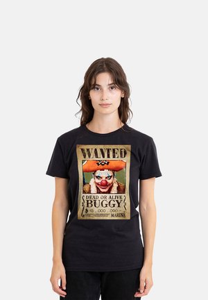 Junge Frau trägt ein schwarzes T-Shirt mit einem Vintage-Stil Steckbrief eines Clowns namens Buggy auf der Vorderseite.