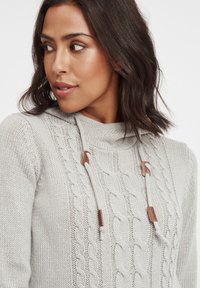 Helles graues Strickpullover mit einem strukturierten Zopfmuster, Kapuze und braunen Lederdetails an den Kordeln. Weicher Stoff und lässige Passform.
