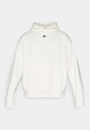 Hvit hettegenser med ribbet tekstur, kengurulomme og logo på brystet. Løs passform og lange ermer.