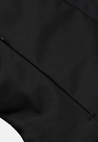 Tessuto nero con una texture liscia, caratterizzato da una cerniera nascosta e un design pulito. Nessun motivo visibile o accentuazione aggiuntiva.