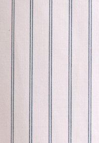 Tissu beige clair avec des fines rayures verticales gris foncé réparties uniformément formant un motif simple.