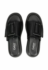 Sandales en cuir noir avec une large sangle ornée d'une boucle rectangulaire, semelle rembourrée et logo de marque en relief.