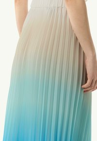 Abito plissettato con sfumature che vanno dal beige chiaro al blu chiaro. Realizzato in tessuto leggero, con vita stretta e una silhouette fluida.