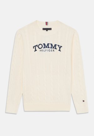 Maglione crema a treccia con collo rotondo, caratterizzato dal logo blu "TOMMY HILFIGER" sul petto e da un piccolo dettaglio con il marchio sulla manica.