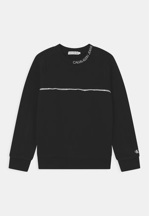 Sort langærmet sweatshirt med hvid Calvin Klein Jeans-logo på kraven, vandret stribe over brystet og lille "ck" på venstre ærme.
