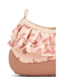 Ljusrosa sko med ett mönstrat tyg med havsdjur, en volangdetalj runt ankeln och en texturerad gummisula.