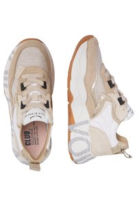Zapatillas beige que presentan una mezcla de texturas de malla y ante, cordones negros y una suela gruesa blanca y de goma con sutiles acentos grises.