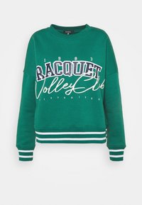 Sudadera corta verde con estampado blanco y azul marino que dice "Racquet Volleyball Club 1983", con puños y dobladillo de rayas en blanco y verde.