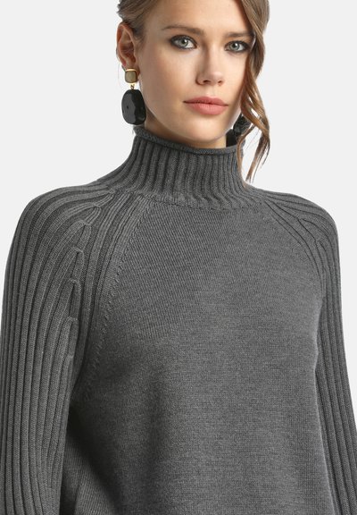 Grauer Rollkragenpullover mit geripptem Textur, ausgestattet mit Zopfmuster-Akzenten an den Ärmeln. Glatte Oberfläche und lockere Passform.