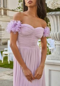 Rochie lavandă off-the-shoulder, cu corset plisat și accente florale transparente pe mâneci. Fustă fluidă, material ușor și design mulat.