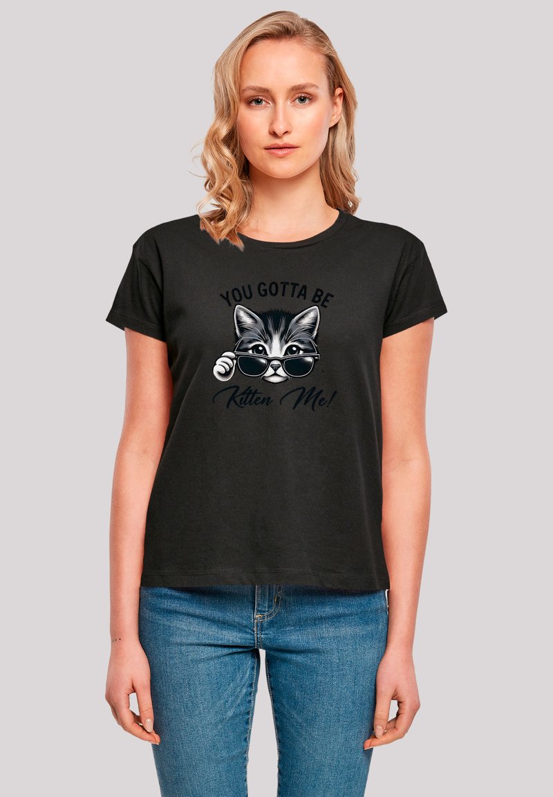 Black t-shirt featuring a graphic of a cat wearing sunglasses, with the text "YOU GOTTA BE KITTEN ME!" in a playful font. Short sleeves, relaxed fit.