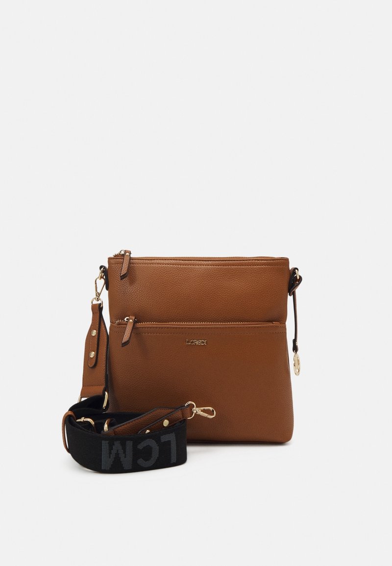 Ruskea nahkainen olkalaukku, jossa on kaksi vetoketjullista osastoa, kultainen logo ja irrotettava tekstiilihihna, jossa on mustaa tekstiä.