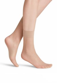 Beige transparente Knöchelstrümpfe mit elastischem Bund oben, glatte Textur und offenes Zehen-Design, auf baren Füßen dargestellt.