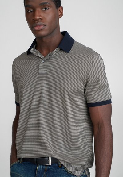 Heren polo met korte mouwen in een gemêleerd grijs en marineblauw ontwerp, met een effen marineblauwe kraag en een textuurstof. Casual pasvorm, gecombineerd met blauwe jeans.