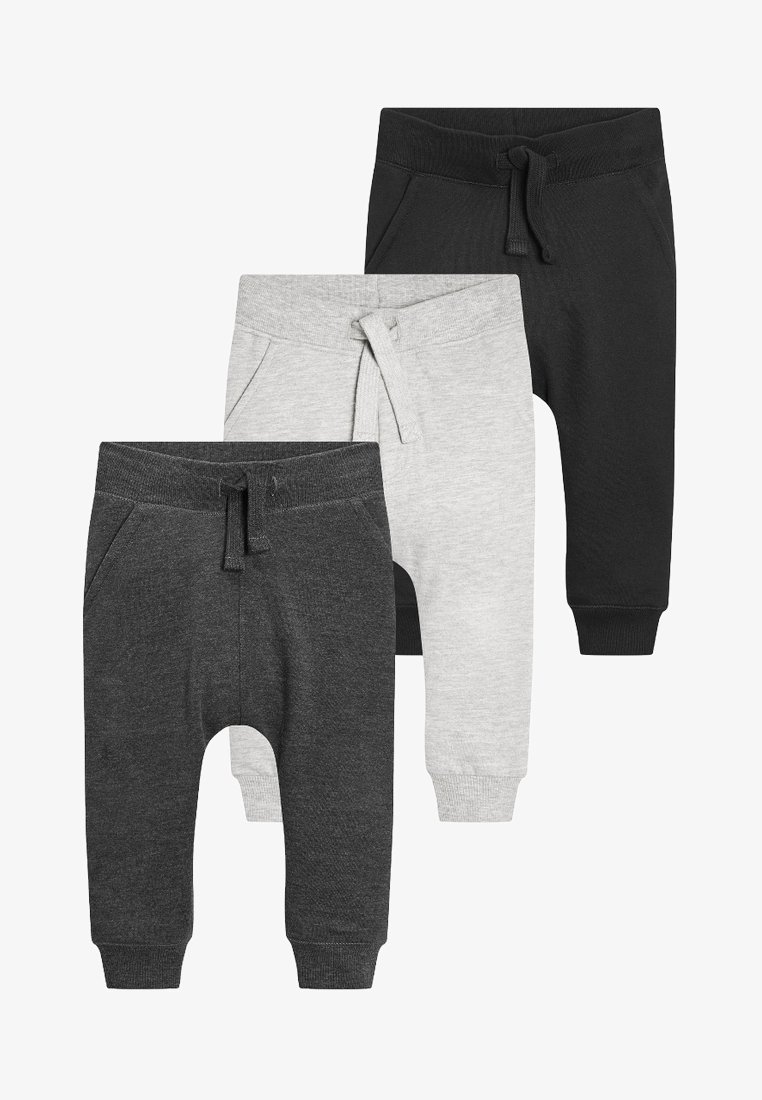 Tres pares de pantalones de chándal para niños pequeños en negro, gris y gris oscuro. Fabricados con un tejido suave, cuentan con cinturillas elásticas y bolsillos laterales.
