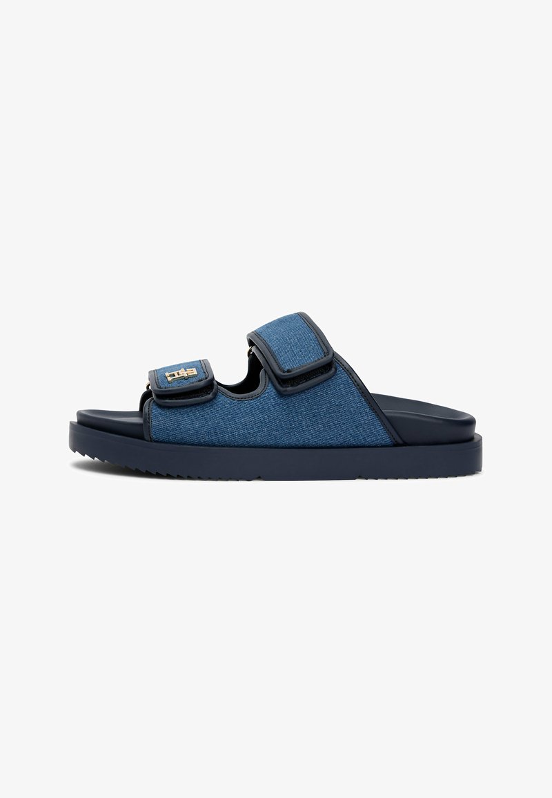 Sandale à glissière pour homme de couleur bleu marine avec deux brides réglables en denim et semelle en caoutchouc noir, vue de côté sur fond blanc.