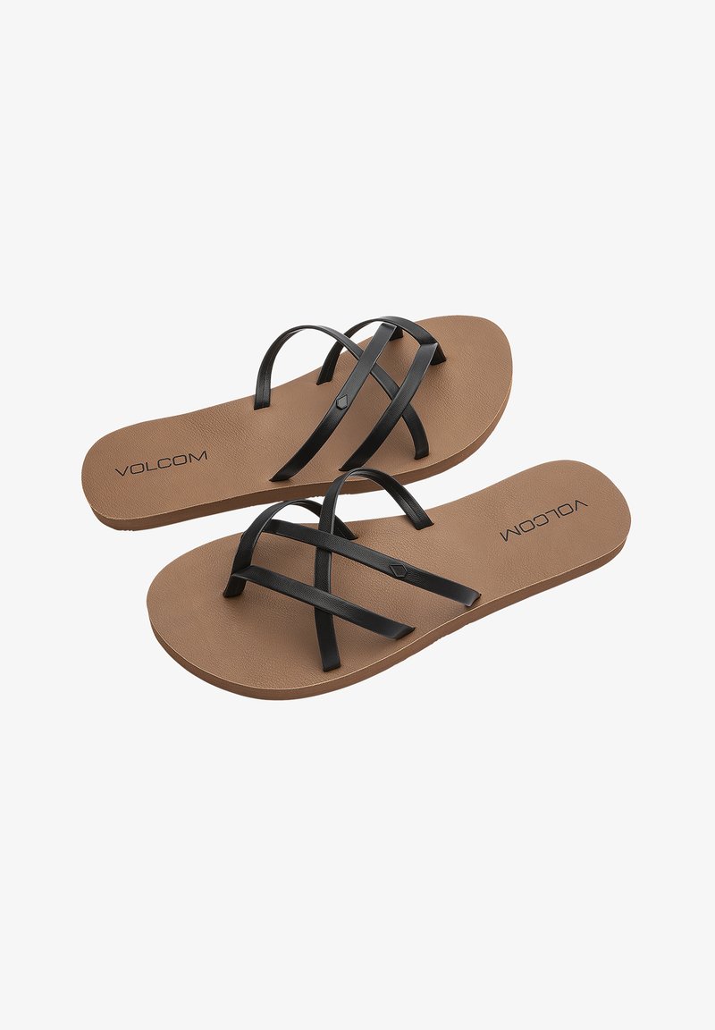 Black strapped flip-flops with a tan rubber sole, featuring two crisscross straps and embossed "VOLCOM" logo on the insole.