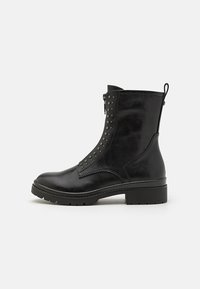 Schwarze Leder-Ankle Boots mit seitlichem Reißverschluss, Nietenverzierungen, runder Zehenpartie und strukturiertem Gummisohle. Mit einer Zuglasche für einfaches Anziehen.