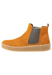 Bottines en daim jaune moutarde avec un panneau latéral en élastique gris texturé. Équipées d'une semelle en gomme rainurée et d'une tirette à l'arrière pour un enfilage facile.