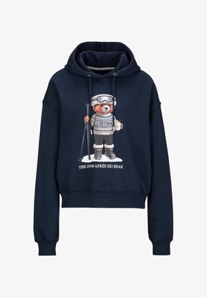 Marineblauwe cropped hoodie met een beerafbeelding in skikleding, die skies en een mok vasthoudt, met witte sweatshirtdetails en tekst eronder.