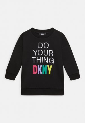 Sort langærmet sweatshirt med hvid tekst "DO YOUR THING" og farverigt "DKNY"-logo foran mod en ensfarvet baggrund.