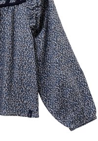 Blusa leopardata blu e nera con un fit morbido, maniche lunghe e polsini elasticizzati. Realizzata in un tessuto leggero con una consistenza morbida.