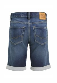 Shorts en denim avec un lavage bleu foncé et des ourlets retroussés. Comprend deux poches arrière avec des coutures courbées et un patch en cuir de marque à la taille.