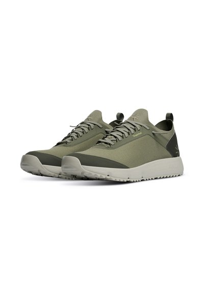 Scarpe da ginnastica verdi con superiore in tessuto testurizzato, suola in gomma e tallone rinforzato. Presentano lacci e un marchio sottile sul lato.