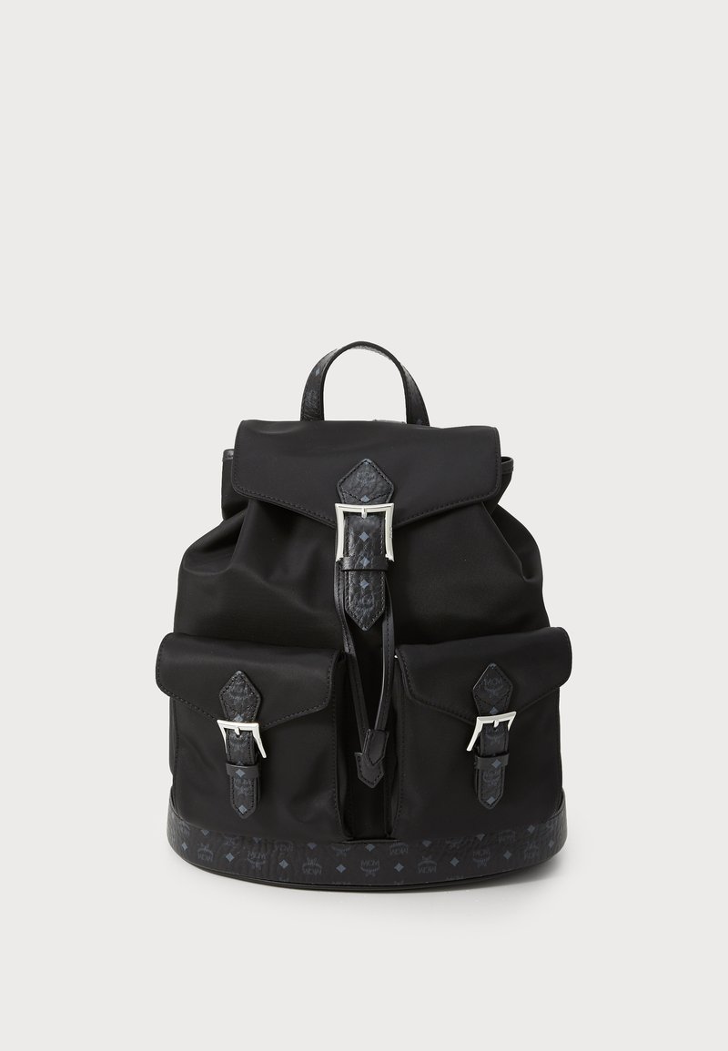 Mochila de nylon negra con dos bolsillos frontales con hebilla, una solapa superior con hebilla y una base y detalles de ribete con patrón.