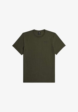 Personne vue de dos portant un t-shirt uni à manches courtes vert olive et un jean en denim bleu sur un fond uni.