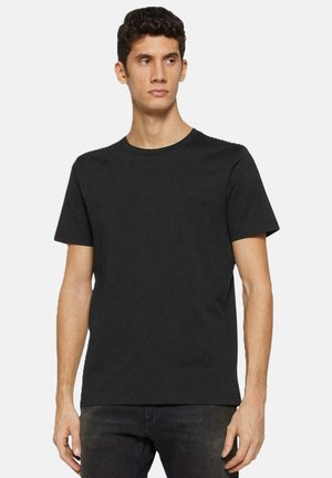 T-shirt nera in cotone con maniche corte, collo rotondo e un minimale dettaglio grafico sul petto. Tessuto morbido e vestibilità regolare.