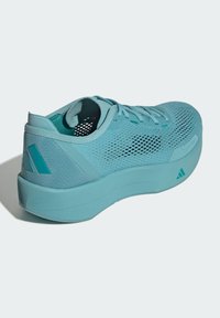 Svetlomodrá športová obuv s vrchnou časťou z mesh materiálu, textúrovanými akcentmi, polstrovanou podrážkou a logom na päte.