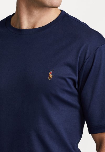 Navy blue short-sleeve T-shirt made of cotton, featuring a small embroidered logo of a polo player on the left chest. Smooth texture.