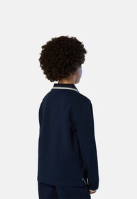 Camicia a maniche lunghe blu navy con colletto a contrasto bianco rifinito, caratterizzata da una vestibilità comoda e fessure laterali all'orlo.