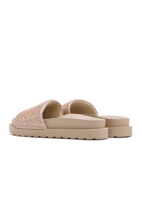 Geweven slidesandalen met een gestructureerde roze bovenkant en een beige, stevige zool. Open teenontwerp en platte platform zorgen voor comfort.