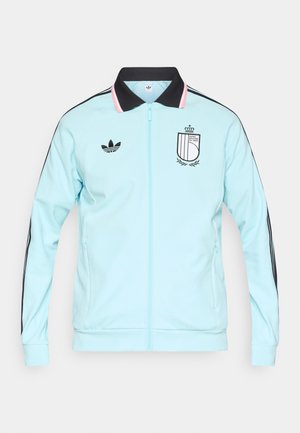 Světlomodrá bunda na zip s černým límcem, s třemi černými pruhy na rukávech a vyšívaným logem na hrudi.