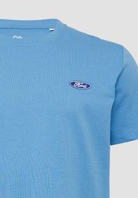 Lichtblauw katoenen t-shirt met een ronde hals, korte mouwen en een klein blauw geborduurd Ford-logo op de borst.