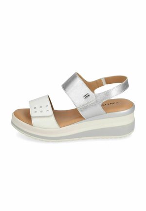 Sandalo con zeppa da donna bianco e argento con cinturini regolabili e suola imbottita su sfondo bianco.