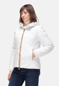 Giacca bianca isolata con chiusura a zip caratterizzata da una zip multicolore. Design con cappuccio, tasche laterali e una texture liscia e lucida.