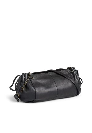 Sac à bandoulière en cuir noir avec fermeture à cordon et détail chaîne, posé sur un fond blanc.