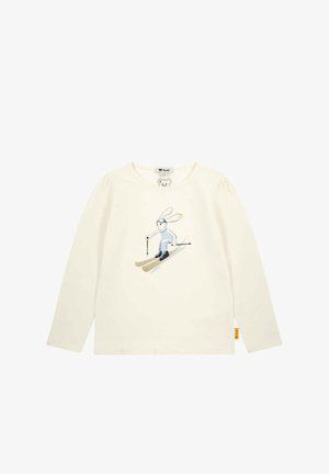Long-sleeve cream shirt made of soft cotton, featuring a skiing rabbit graphic in blue and black, with glittery gold ski equipment accents.