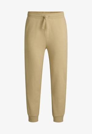 Beige sweatpants met een verstelbare tailleband, taps toelopende benen en ribbels aan de onderkant. Gemaakt van zachte katoenmix stof. Geen zichtbare patronen.