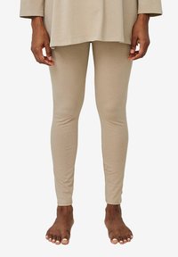 Beige Leggings aus weichem, dehnbarem Material, mit einem figurbetonten Design und einer glatten Textur. Keine sichtbaren Muster oder Beschläge.