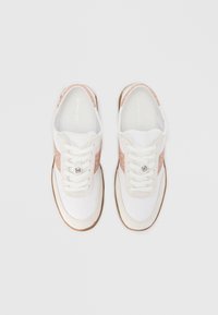 Baskets blanches et rose clair, avec une tige lisse, un bout arrondi, une fermeture à lacets et un panneau latéral texturé. Semelle légère en caoutchouc.