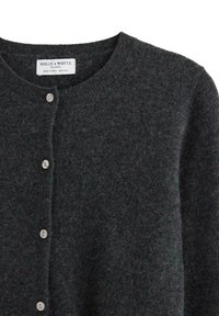 Tmavě šedý vlněný kardigan s kulatým výstřihem, pěti malými světlými knoflíky a štítkem "HOLLY & WHYTE by LINDEX" uvnitř límce.