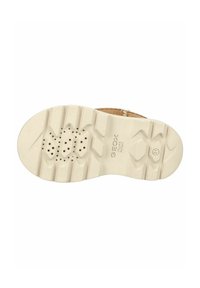 Semelle de chaussure Geox, avec une base en caoutchouc blanc texturé présentant un motif en zigzag et des trous de ventilation. Bord supérieur brun clair visible.