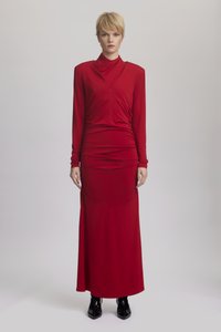 Κόκκινο μαξι φόρεμα με ψηλό λαιμό, μακριά μανίκια και ραντάρισμα στη μέση, συνδυασμένο με κομψά μαύρα μποτάκια μέχρι τον αστράγαλο.